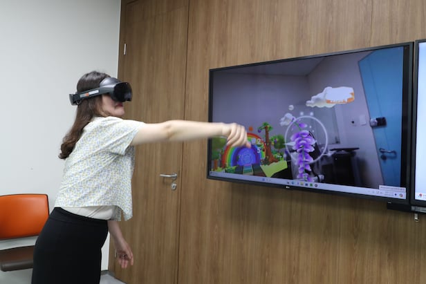 A Bundang CHA Hospital researcher uses a VR therapy device developed by Professor Kim Min-young of rehabilitation medicine. A patient who cannot properly raise an arm trains to catch butterflies in a virtual world and naturally gains rehabilitative benefits./Courtesy of Jeon Gi-byeong