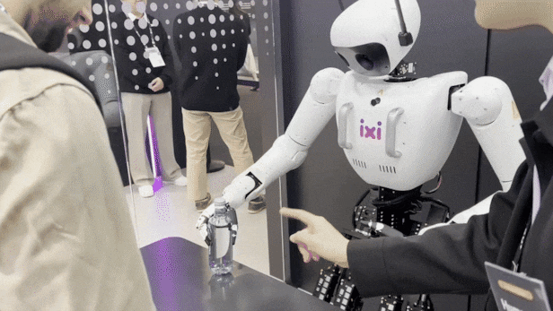 The LG Uplus humanoid robot Alice is seen handing a gift to a visitor. /Courtesy of ChosunBizDB