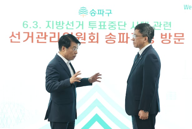 강동완 중앙선거관리위원회  사무차장(오른쪽)이 24일 서울 송파구청에서 6ㆍ3 지방선거 본투표 과정 발생한 송파구 일대 투표용지 부족 사태와 관련해 사과를 한 뒤 서강석 송파구청장과 대화를 나누고 있다. /연합뉴스